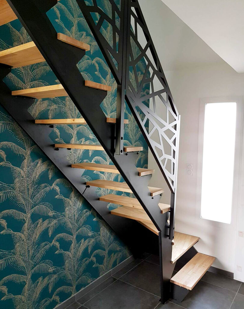 Photo d'une montée d'escalier en bois avec un mur en tapisserie