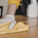 Personne qui nettoie un escalier en bois avec un chiffon