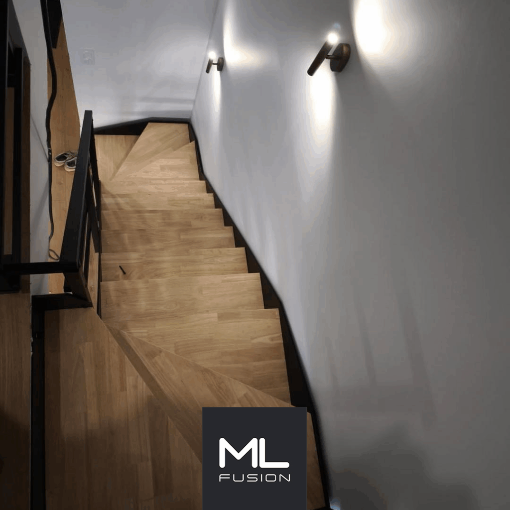 Escalier Rothko en métal et bois, double quart tournant, vu depuis le bas dans une entrée contemporaine.