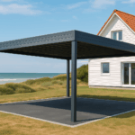 Un carport sur-mesure moderne et résistant aux intempéries, situé dans un paysage côtier à Calais, avec une maison en arrière-plan.