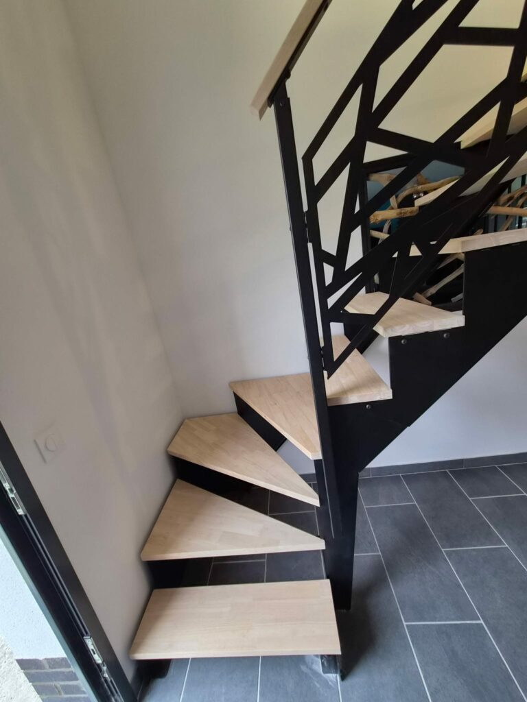 Escalier quart tournant en métal noir avec marches en bois et garde-corps sur mesure dans un intérieur contemporain.