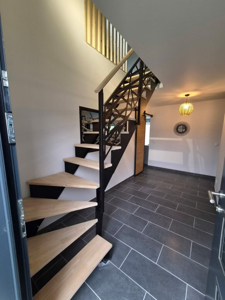 Escalier quart tournant en métal noir avec marches en bois et garde-corps sur mesure dans un intérieur contemporain.