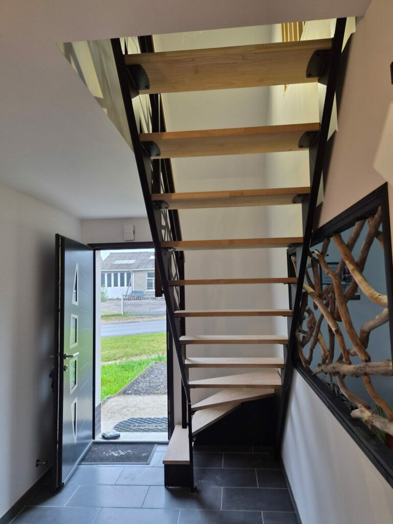 Escalier quart tournant en métal noir avec marches en bois et garde-corps sur mesure dans un intérieur contemporain.