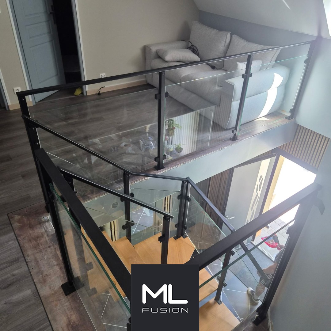 Escalier intérieur avec garde-corps en verre et structure métal noir